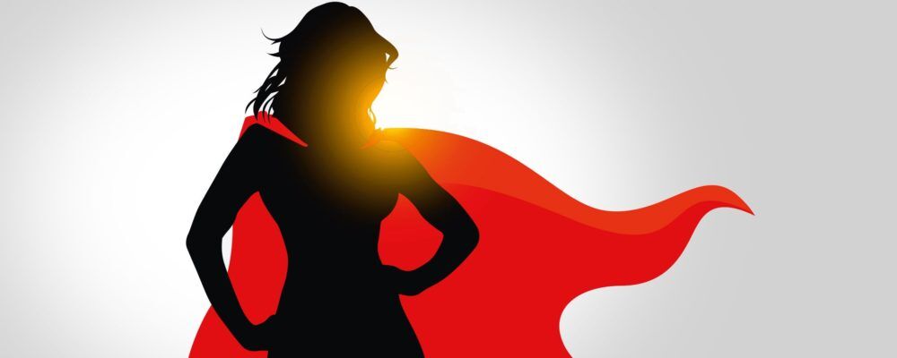 Eine Illustration, die die Silhouette der Comicfigur vom „Superwoman” zeigt, die in einer selbstbewussten Haltung steht. Die Silhouette ist in schwarz, das Cape ist in rot.